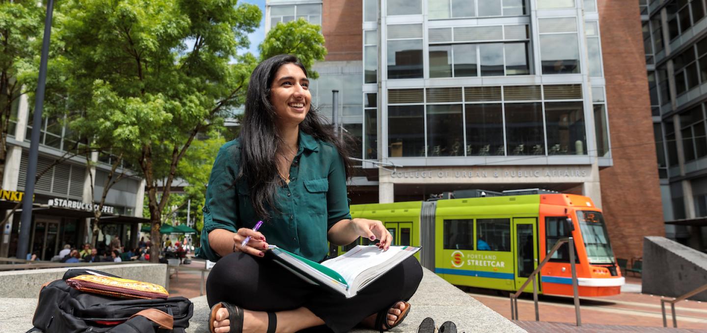 Student Studying outside in summer while streetcar goes by