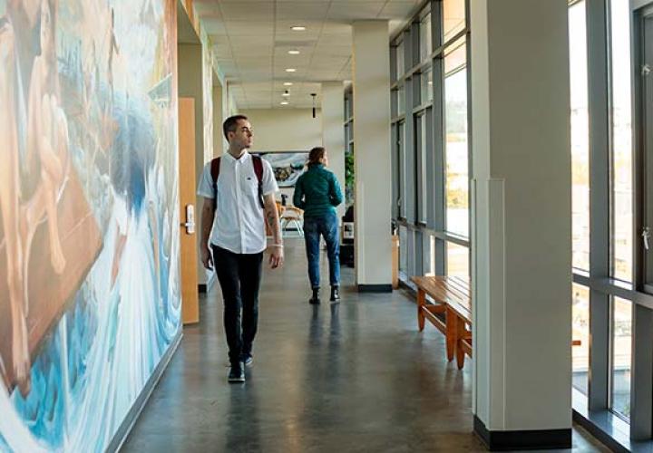 Student walking through hallway in the School of Social Work